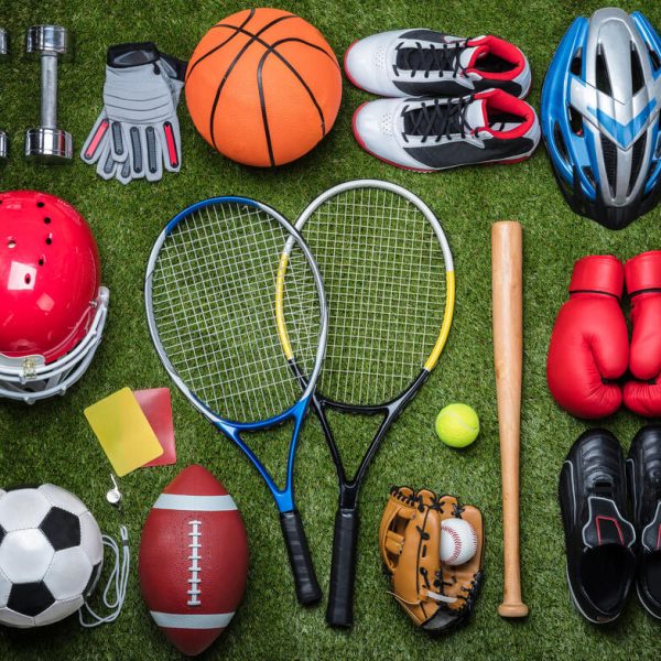 High,Angle,View,Of,Various,Sport,Equipments,On,Green,Grass